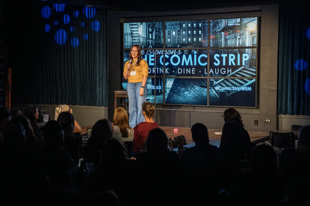Emcee on stage with Comic Strip backdrop